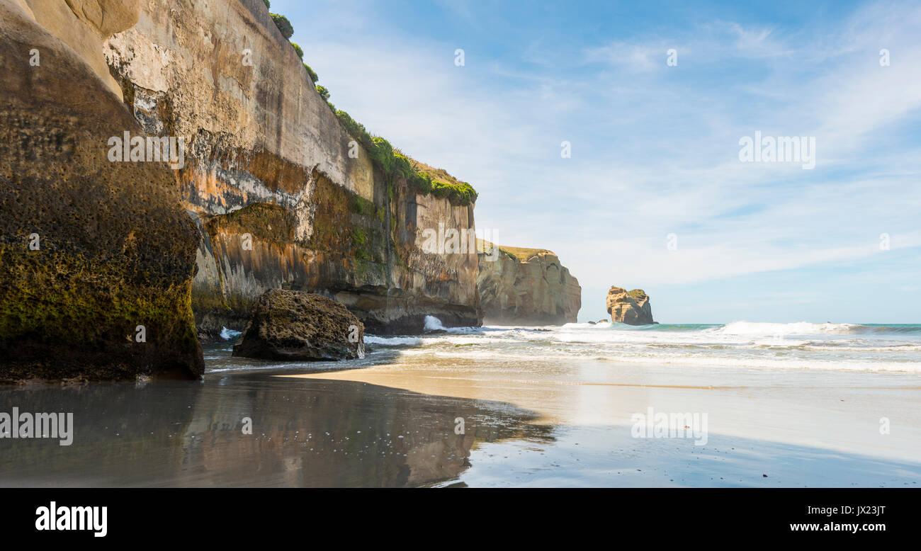 Sandstone rocks towering into the sea, Tunnel Beach, Otago, South Island, New Zealand Stock