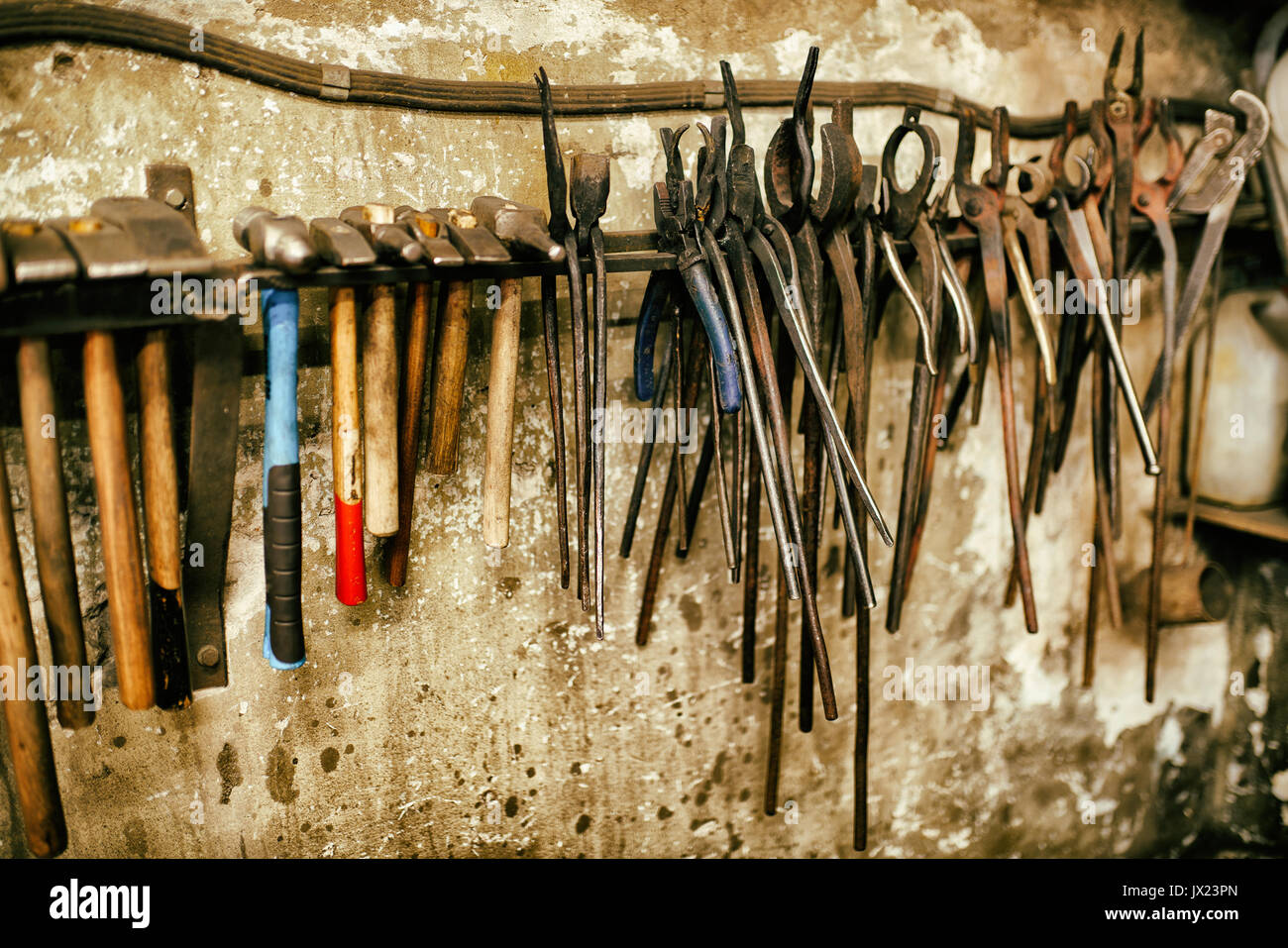 Blacksmith tools in workshop different pliers and hammers Stock Photo