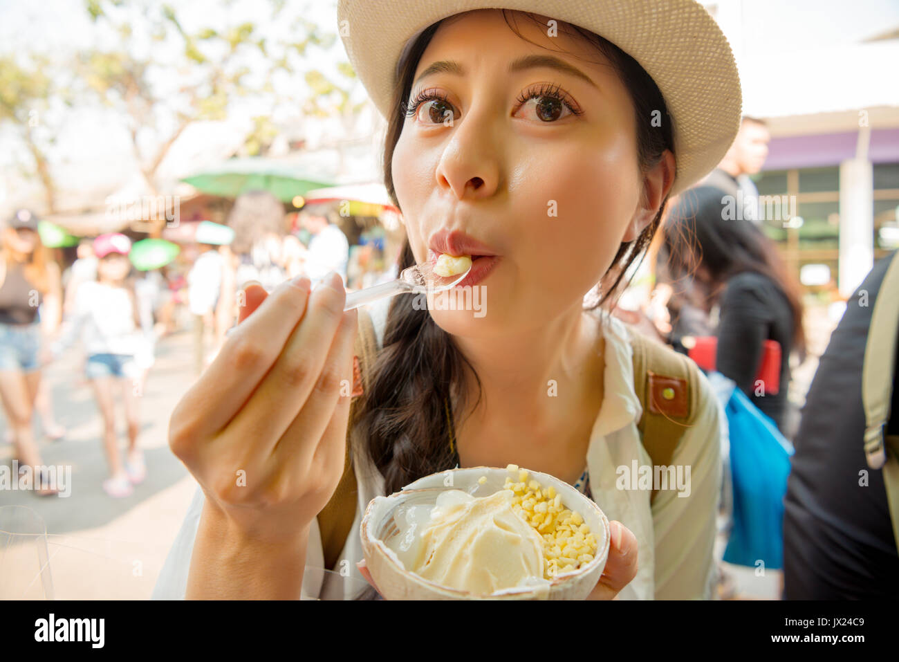 closeup image portrait of female traveler eating enjoying popular coconut i...