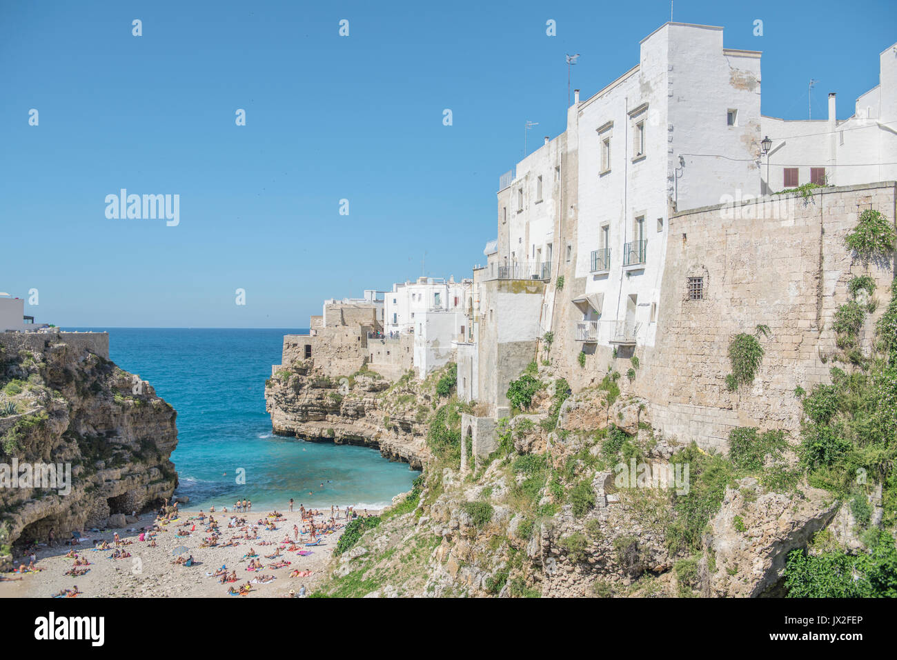 The main beach at Polignano A Mare is nestled in an inlet beneath the Old Town. The famous Red Bull cliff-diving event is held here every year. Stock Photo