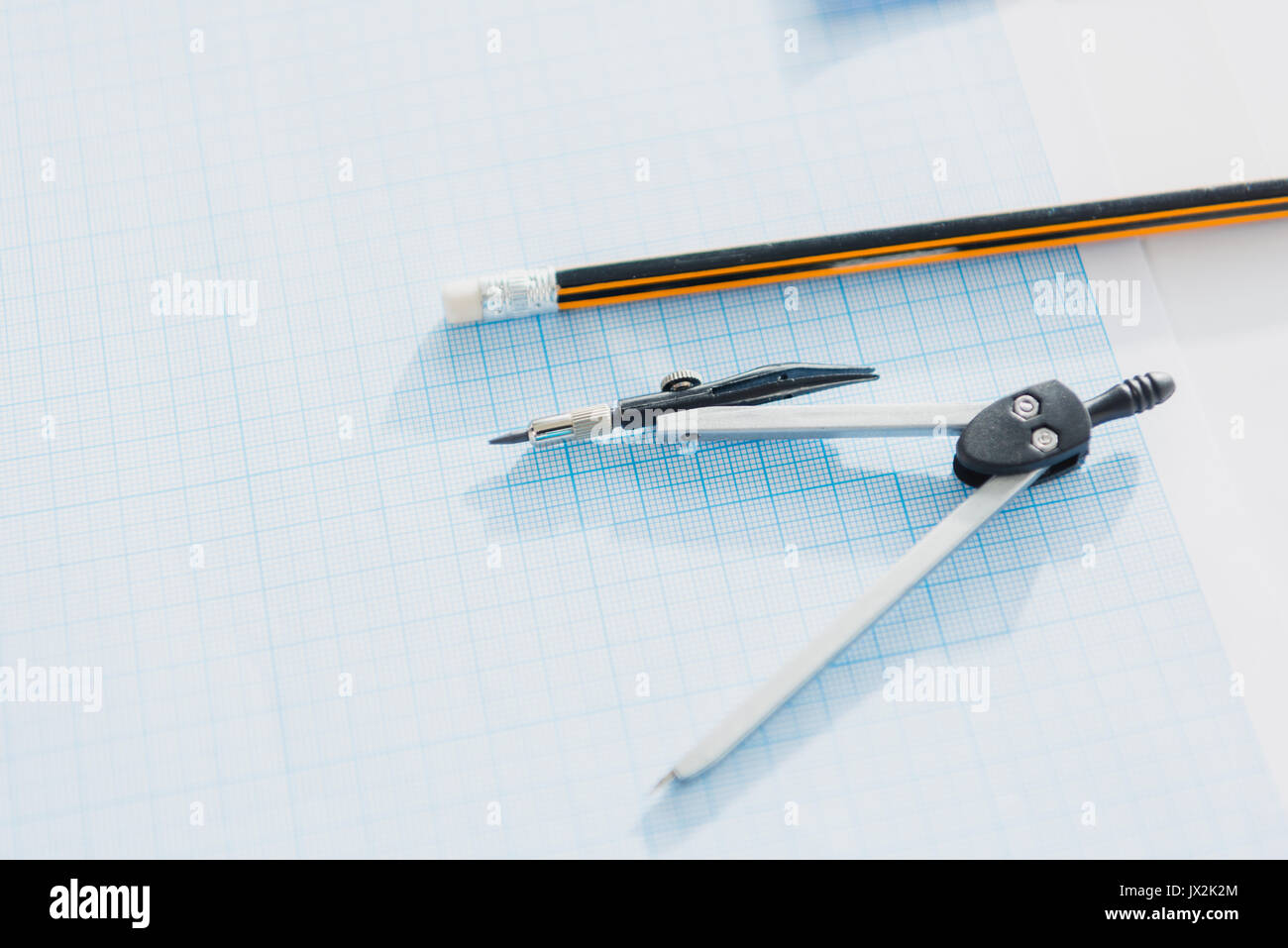 close up of office compasses and pencil lying on empty blueprint, architects desk Stock Photo