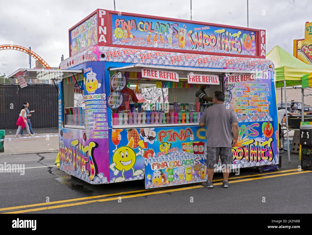 A very colorful stand selling pina coladas and smoothies & offering free refills. At the Coney Island Music festival in Brooklyn, New York Stock Photo