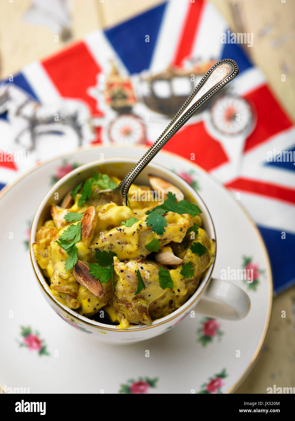 Coronation chicken in tea cup and royal guard and union jack serviette Stock Photo