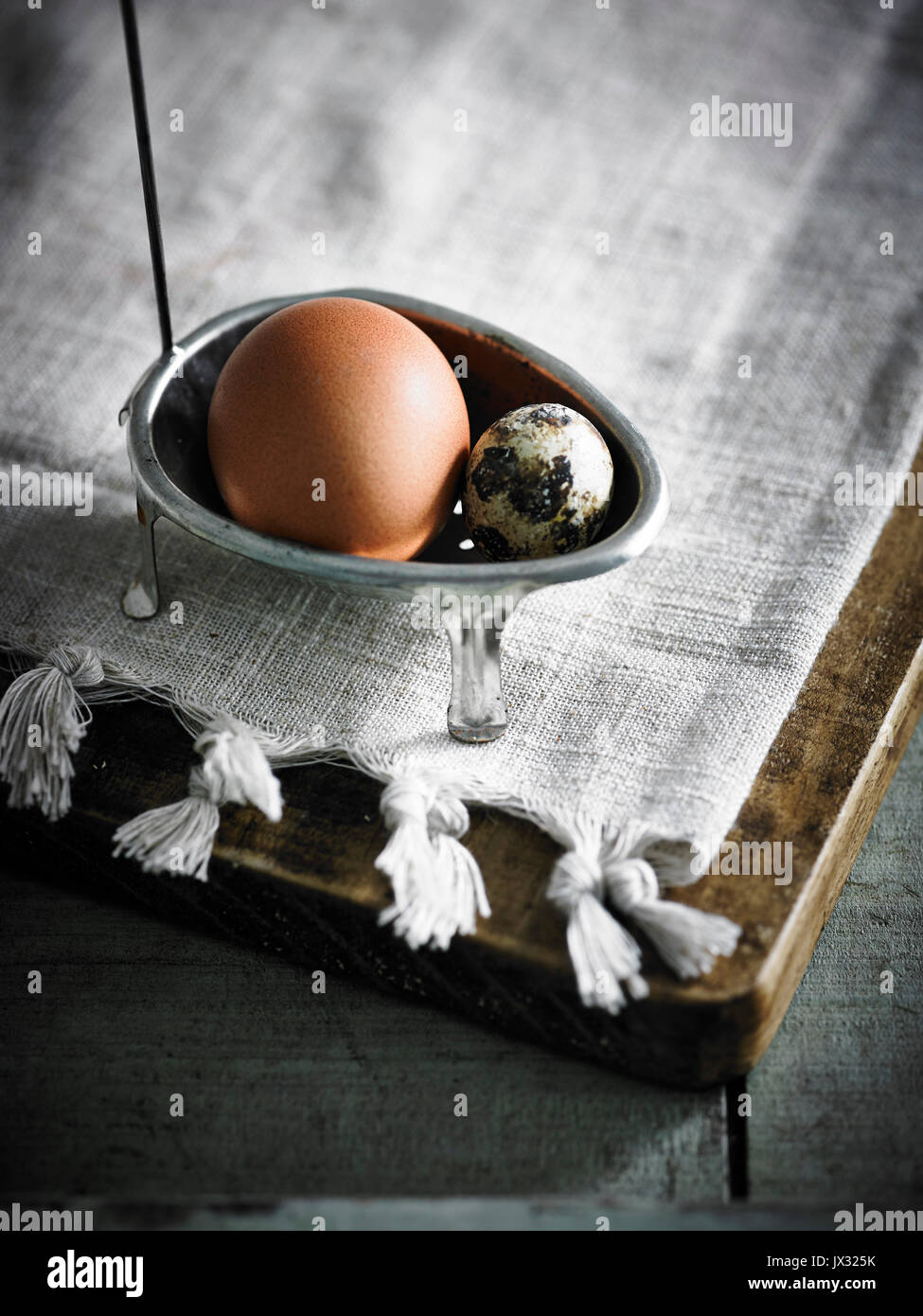 Chicken and quail eggs in poaching spoon Stock Photo Alamy