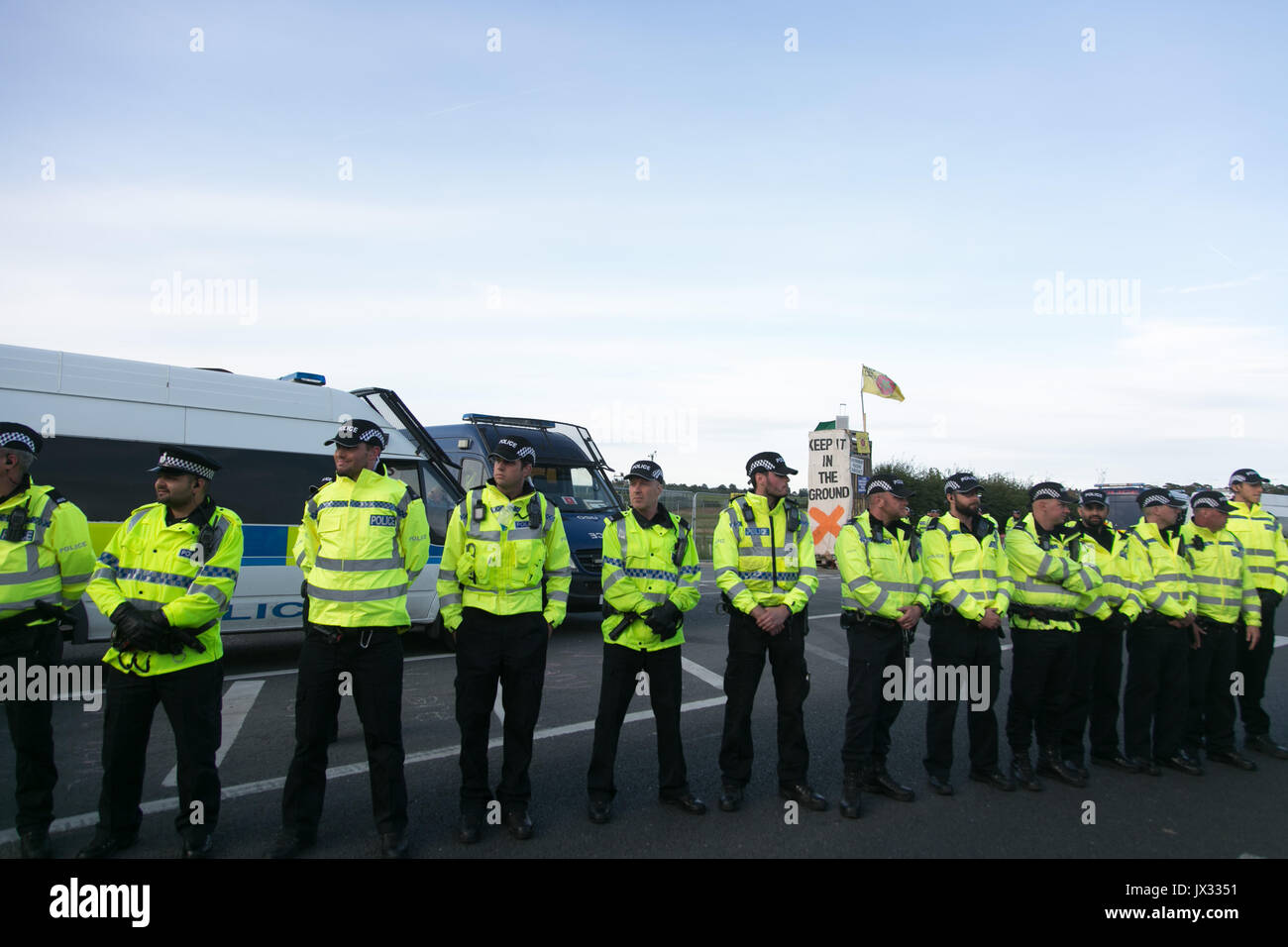 A line of police protects the Quadrilla fracking site in Preston New Road. The entrance had been blocked all day by protesters but now cleared. Stock Photo