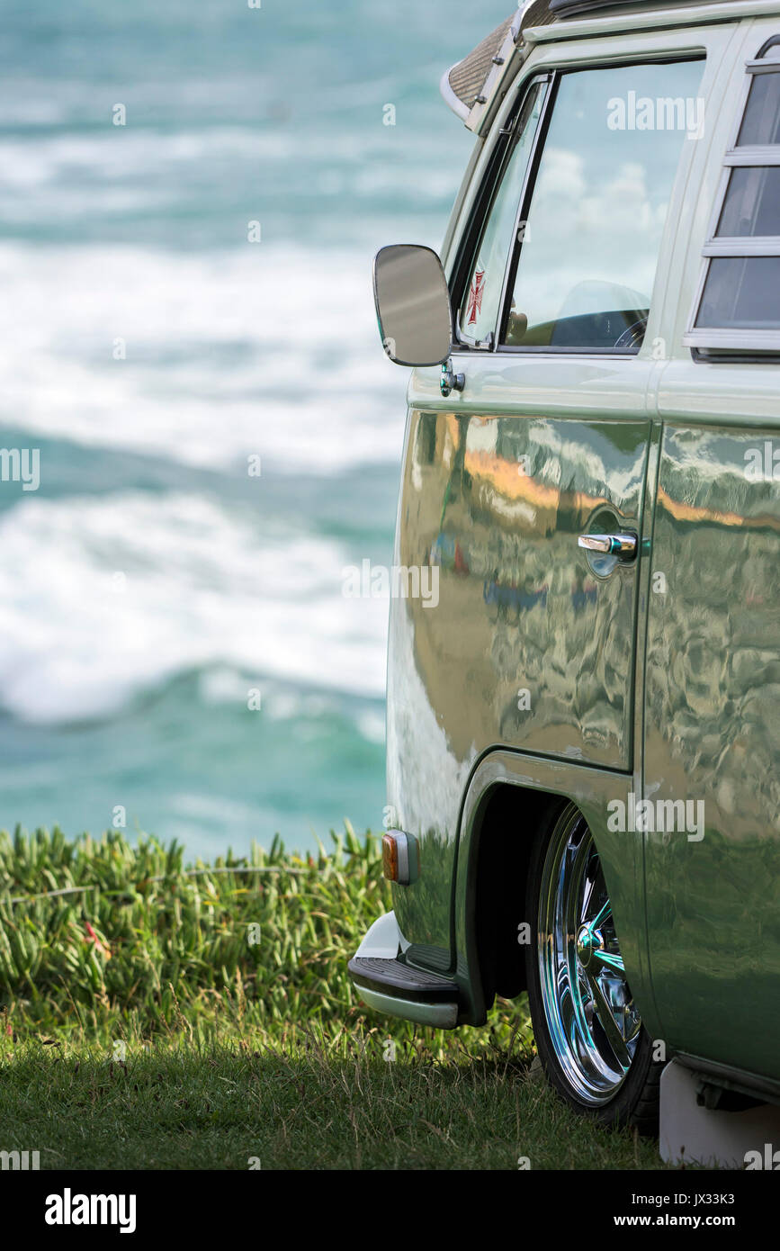 The wing mirror on the side of a vintage VW Campervan parked overlooking the sea. Stock Photo