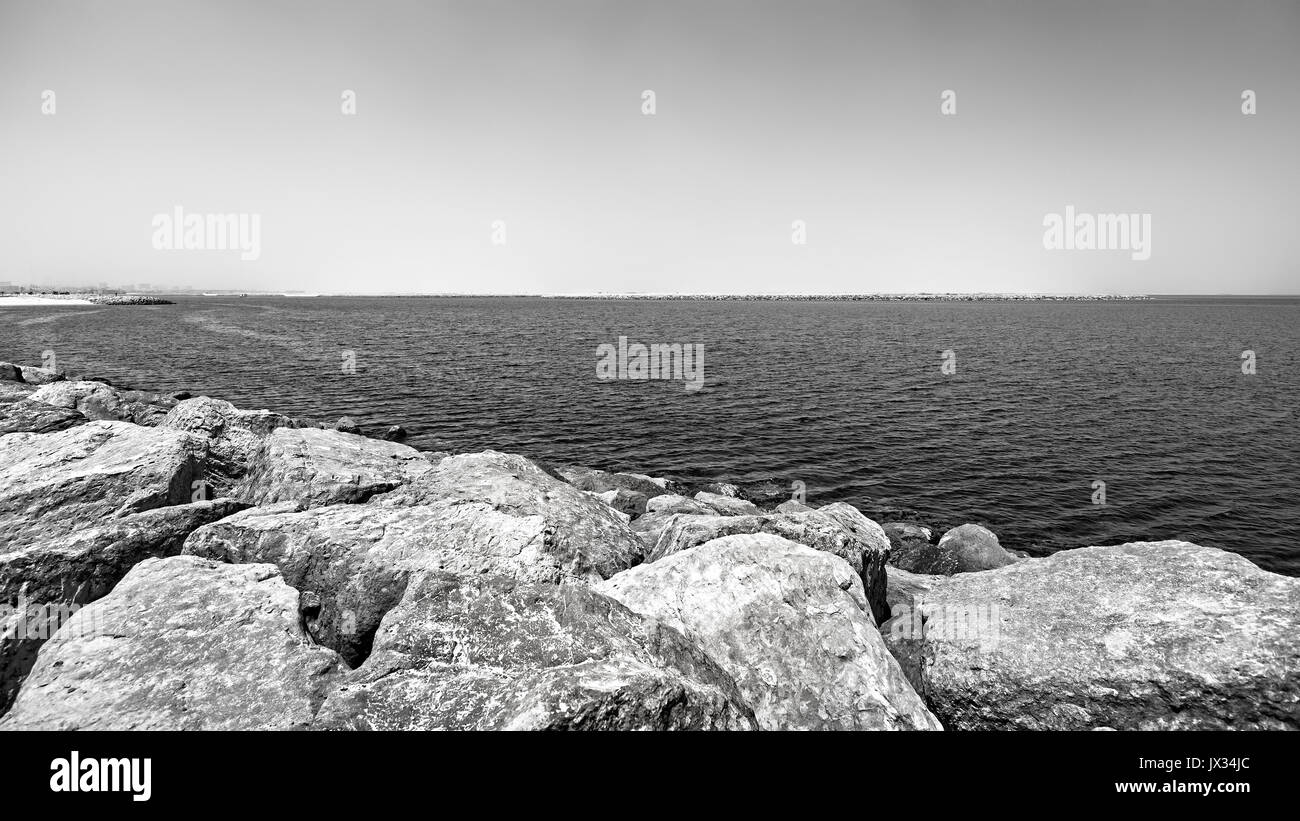 Stony shore minimalistic panorama, black and white toning. Stock Photo