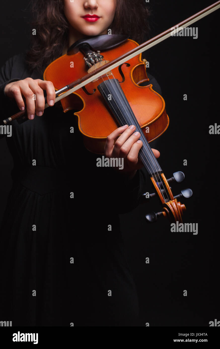 Musical concept. A woman is playing the violin. Focus on the violin Stock Photo