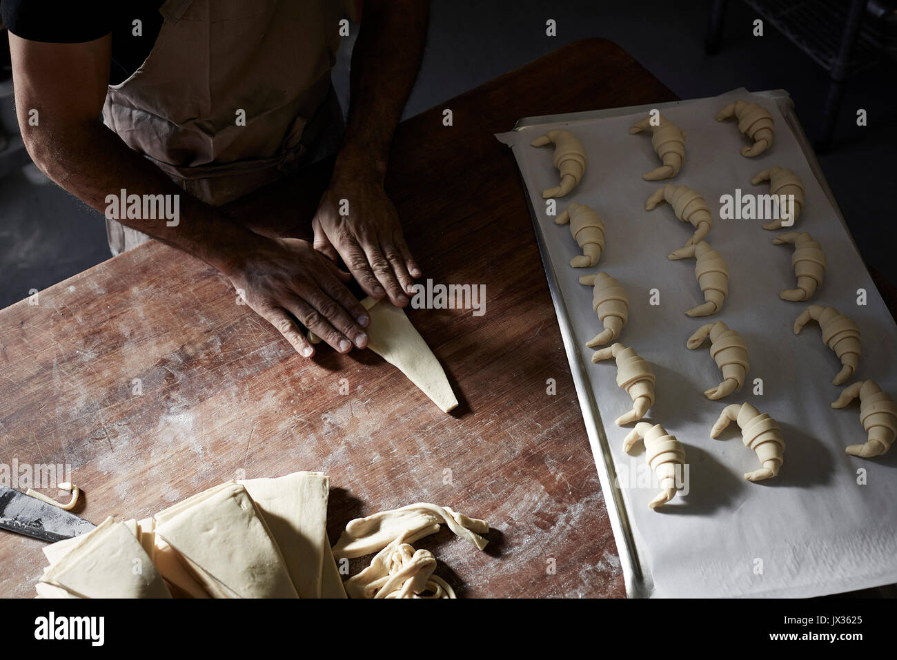 french baker rolling croissants Stock Photo