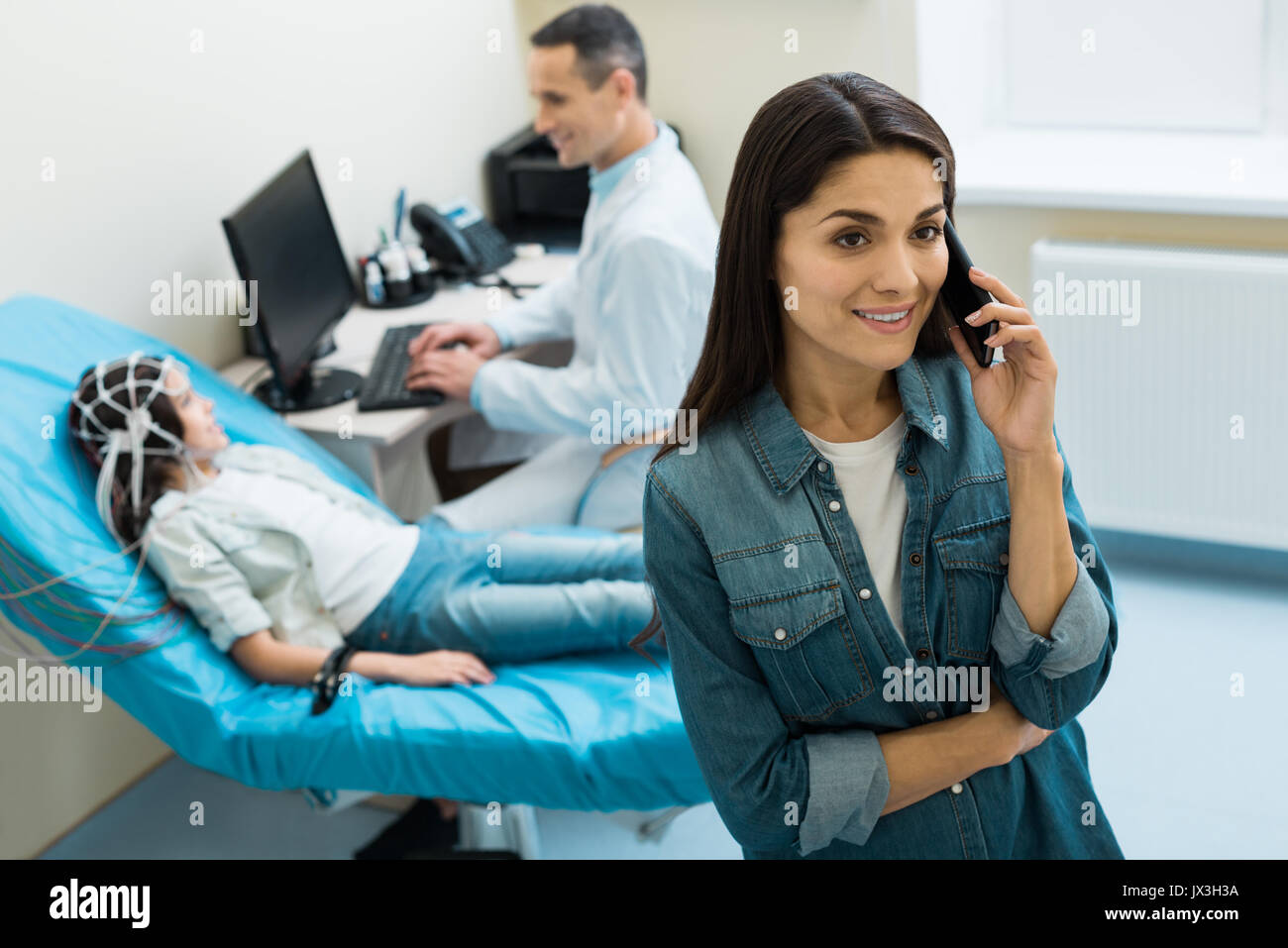 Charming mother of little patient making a phone call Stock Photo