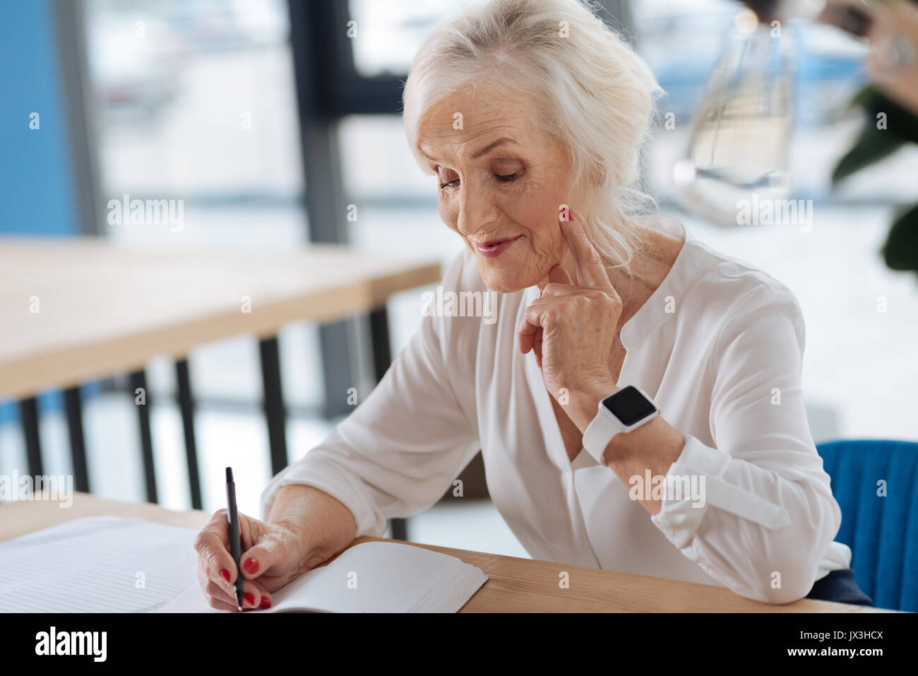 Happy aged woman writing down her memories Stock Photo - Alamy