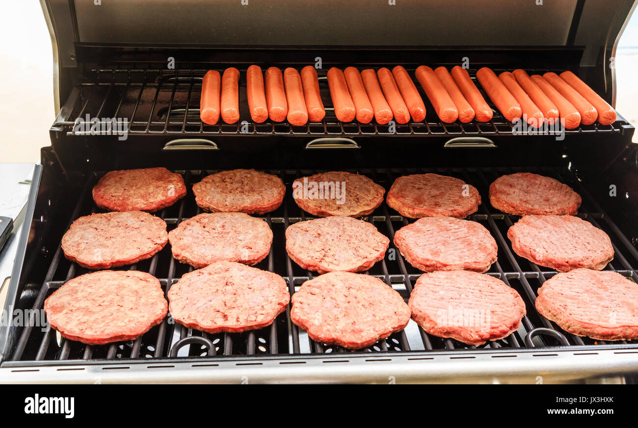 Hamburger Patties and Hot Dogs Cooking on a New Gas Grill Stock Photo -  Alamy