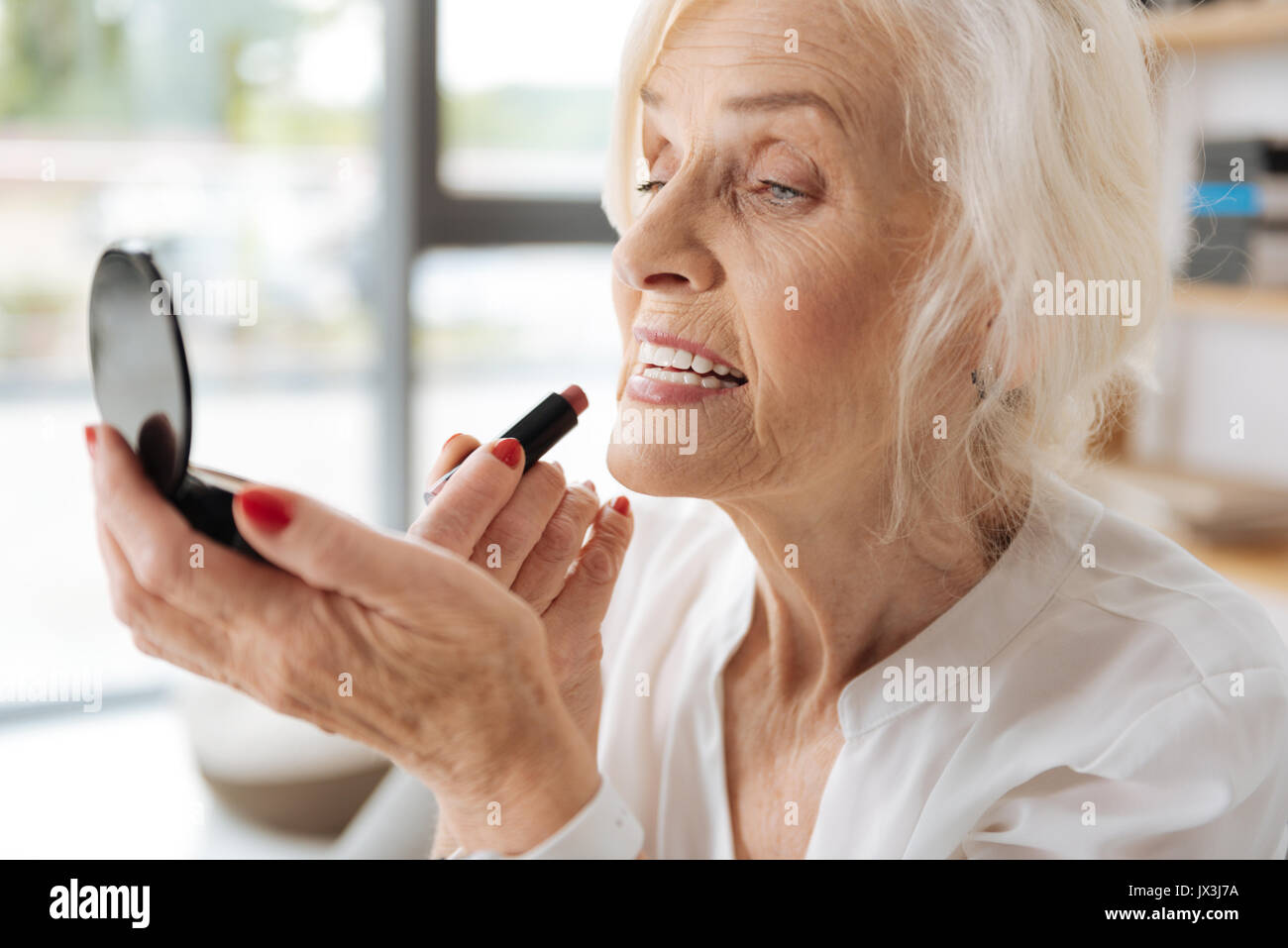 Nice senior woman putting on makeup Stock Photo Alamy