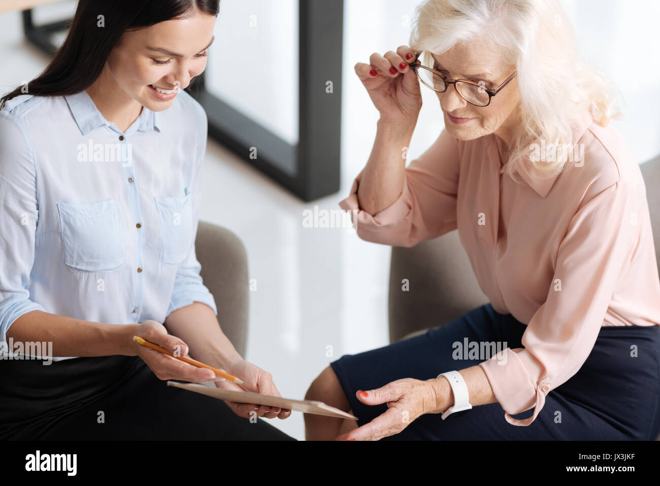 Pleasant young assistant showing her boss a document Stock Photo