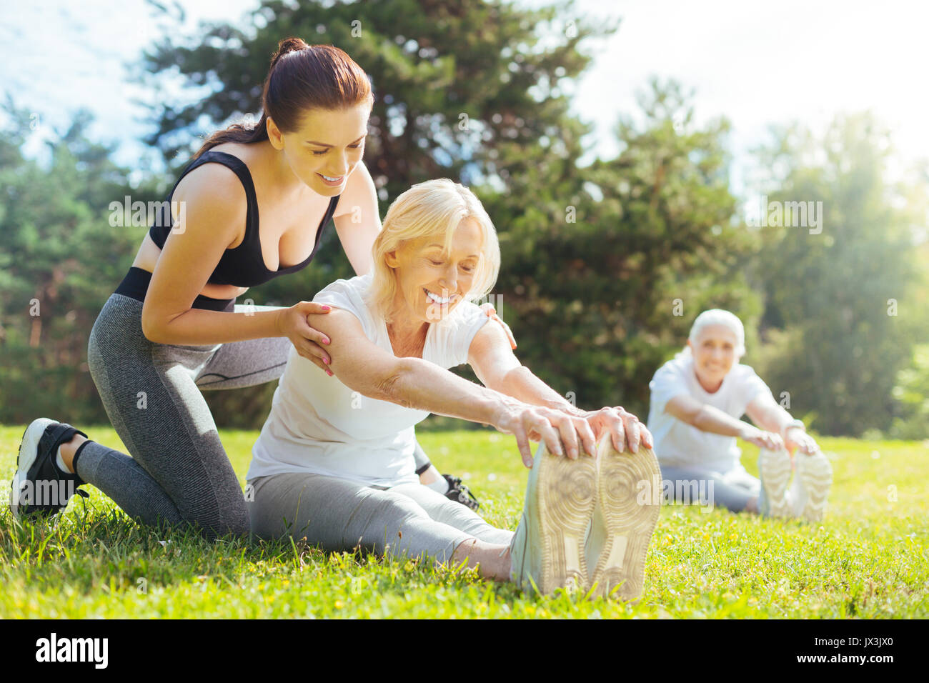Happy women doing stretching task together Stock Photo - Alamy