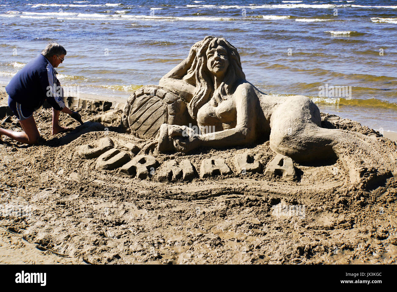Artist makes a sand sculpture of a Mermaid. Photographed in Jurmala, Latvia Stock Photo