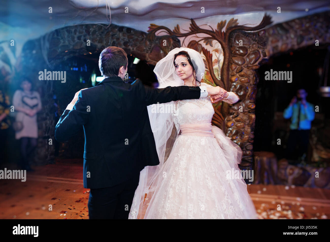 Wedding couple dancing their first dance in the restaurant with ...