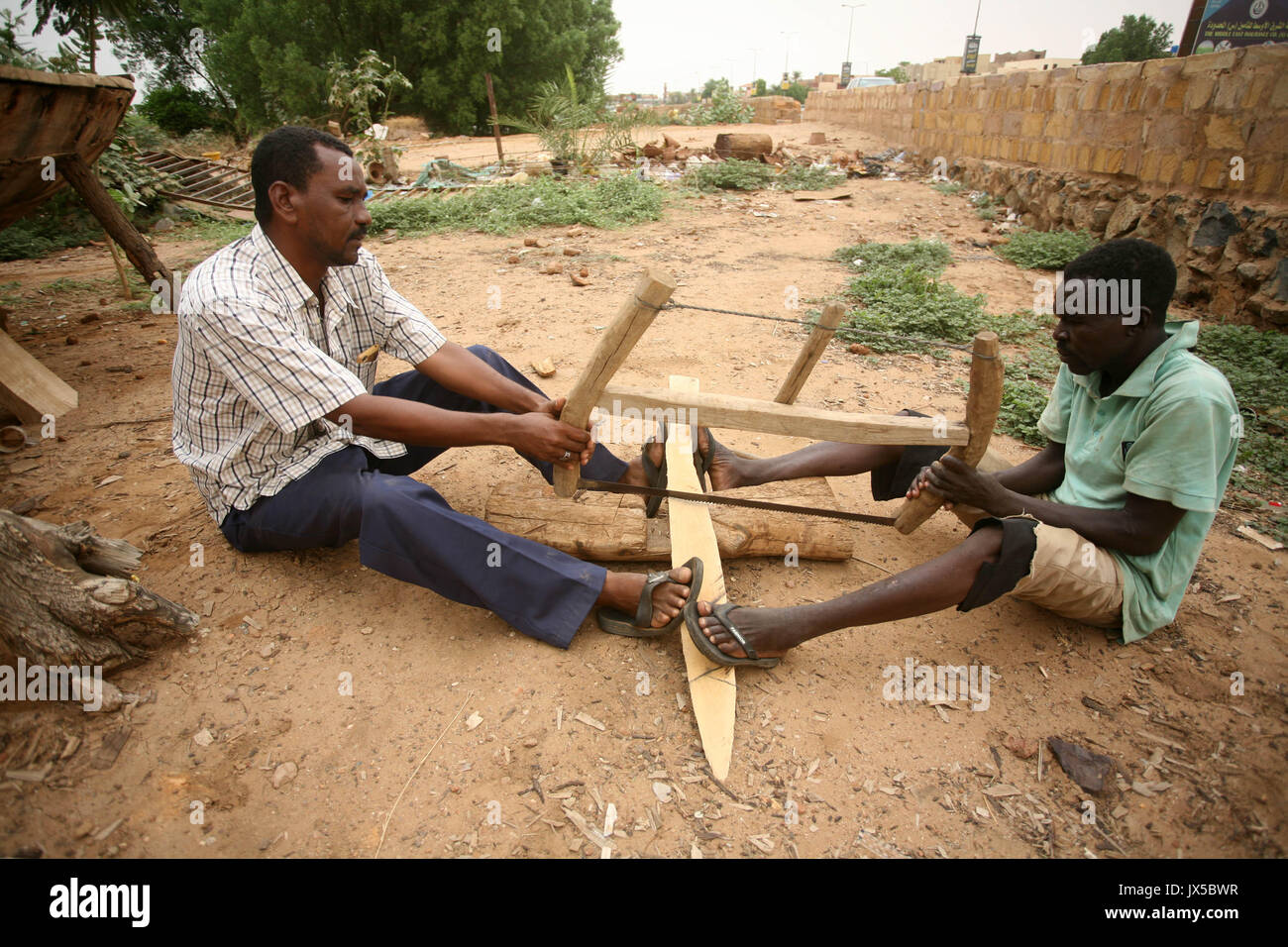 Khartoum, Sudan. 14th Aug, 2017. People make a wooden boat on the shore of the Nile at Abu Raouf area of Omdurman city, Sudan, on Aug. 14, 2017. Wooden boats in Sudan are still favored today as a means to cross the Nile River, particularly during seasonal flooding of the Nile, when levels of the river rise as a natural cycle since ancient times. The islanders and fishermen depend heavily on these traditional boats to transport their goods and personal belongings across the river, as the region is entering a season of Nile flooding. Credit: Mohamed Khidir/Xinhua/Alamy Live News Stock Photo