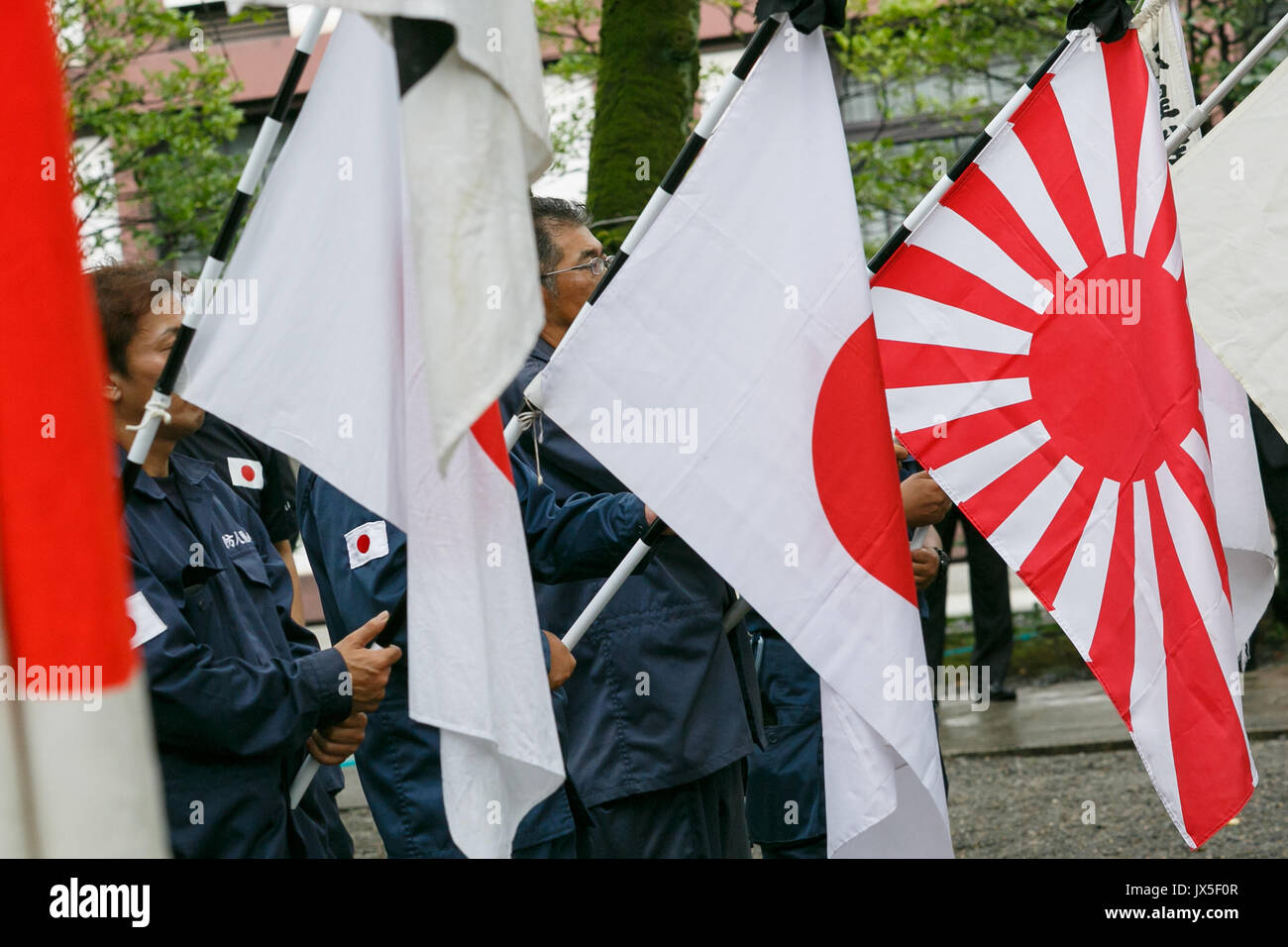 Tokyo, Japan. 15th Aug, 2017. Japanese nationalists dressed in military uniform hold war flags of the Imperial Japanese Army to pay their respects to the war dead at Yasukuni Shrine on the 72nd anniversary of Japan's surrender in World War II on August 15, 2017, Tokyo, Japan. Prime Minister Shinzo Abe was not among the lawmakers to visit the Shrine and instead sent a ritual offering to avoid angering neighboring countries who also associate Yasukuni with war criminals and Japan's imperial past. Credit: Rodrigo Reyes Marin/AFLO/Alamy Live News Stock Photo