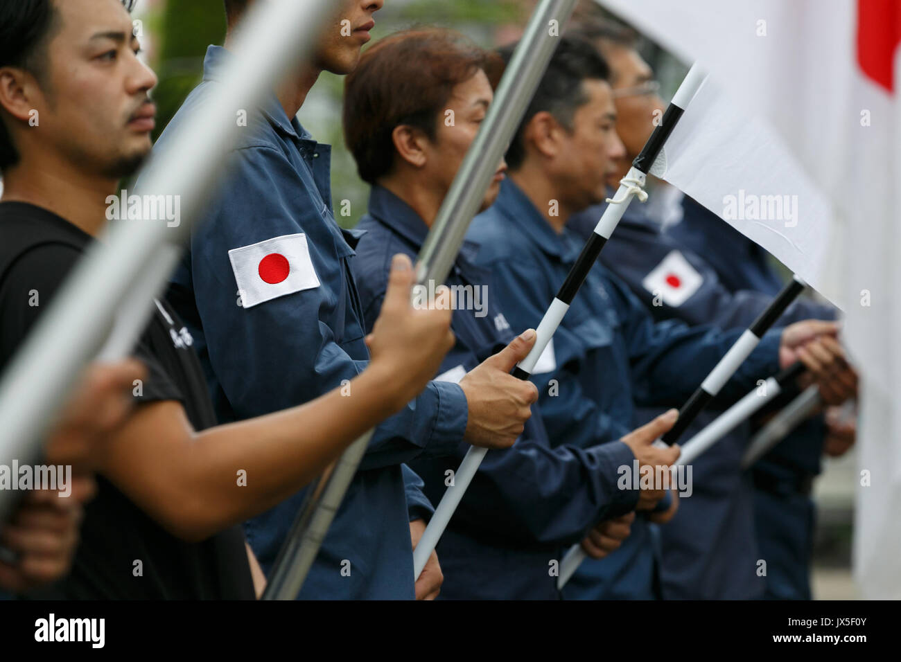 Tokyo, Japan. 15th Aug, 2017. Japanese nationalists dressed in military uniform hold war flags of the Imperial Japanese Army to pay their respects to the war dead at Yasukuni Shrine on the 72nd anniversary of Japan's surrender in World War II on August 15, 2017, Tokyo, Japan. Prime Minister Shinzo Abe was not among the lawmakers to visit the Shrine and instead sent a ritual offering to avoid angering neighboring countries who also associate Yasukuni with war criminals and Japan's imperial past. Credit: Rodrigo Reyes Marin/AFLO/Alamy Live News Stock Photo