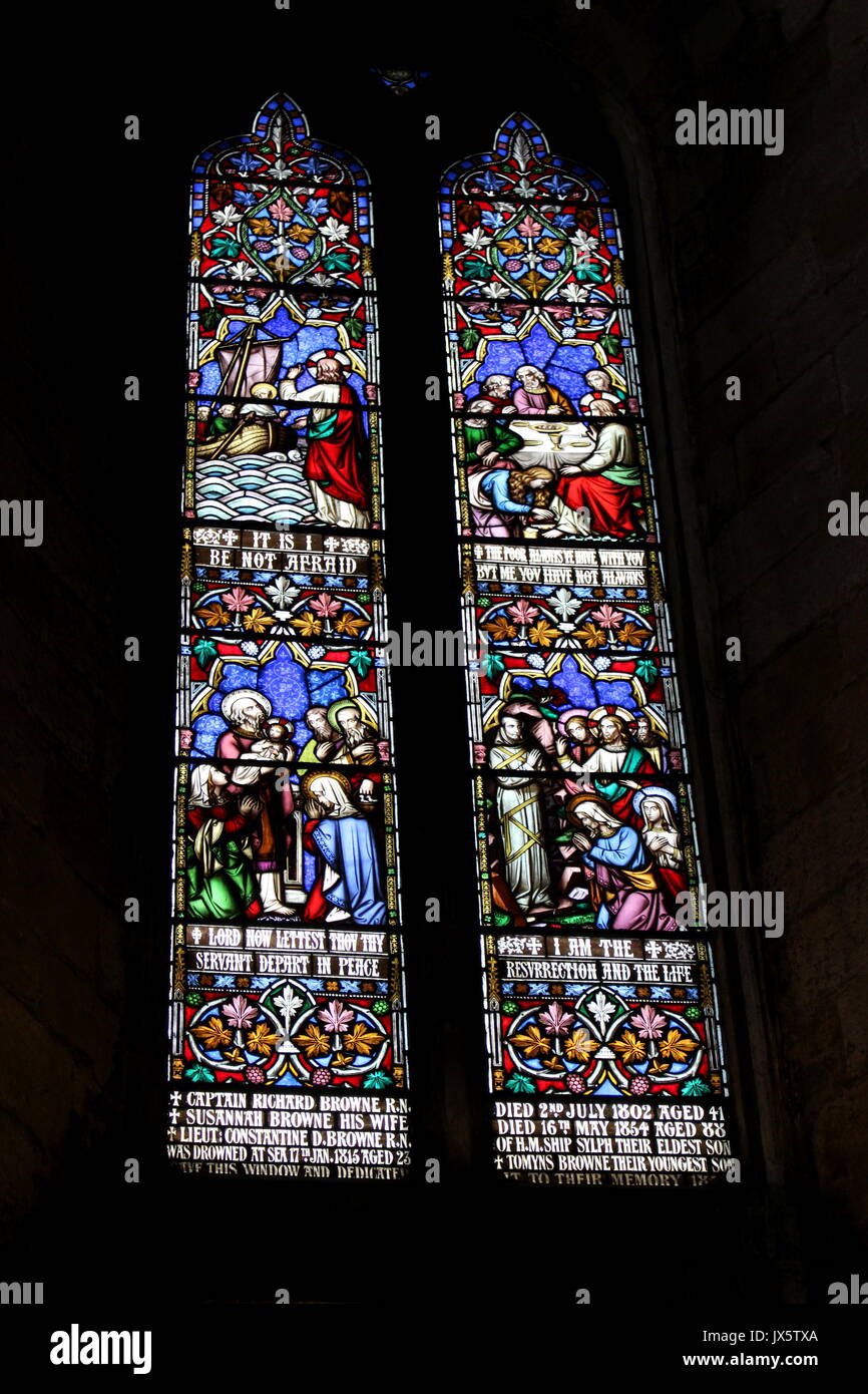 Stained glass window in Ripon Cathedral, with various scenes from the life of Jesus and bible quotes Stock Photo picture
