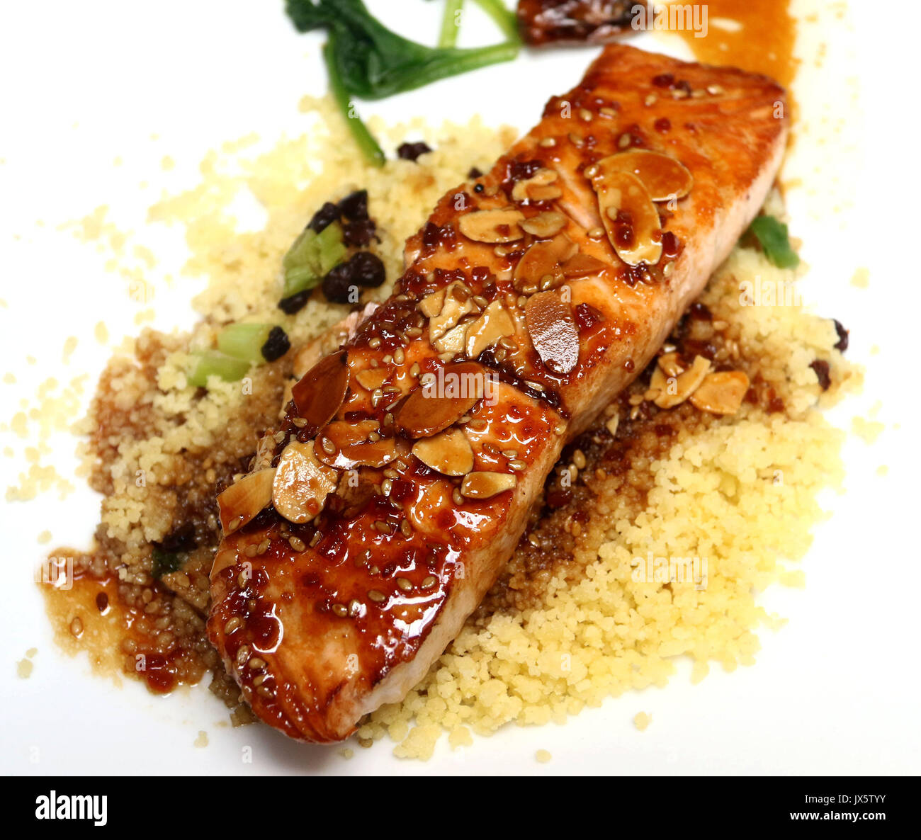 Glazed salmon fillet covered with sliced almonds and teriyaki sauce on a bed of couscous Stock Photo