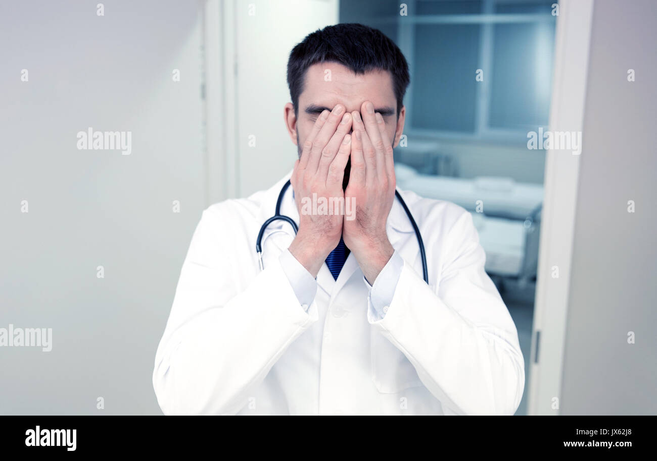 sad or crying male doctor at hospital ward Stock Photo