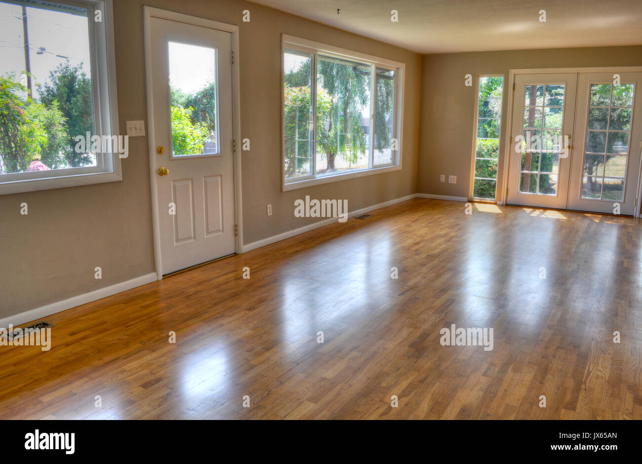 Interior empty living room with no furniture and no people.  Residential with front door and French glass doors and hardwood floors. Stock Photo