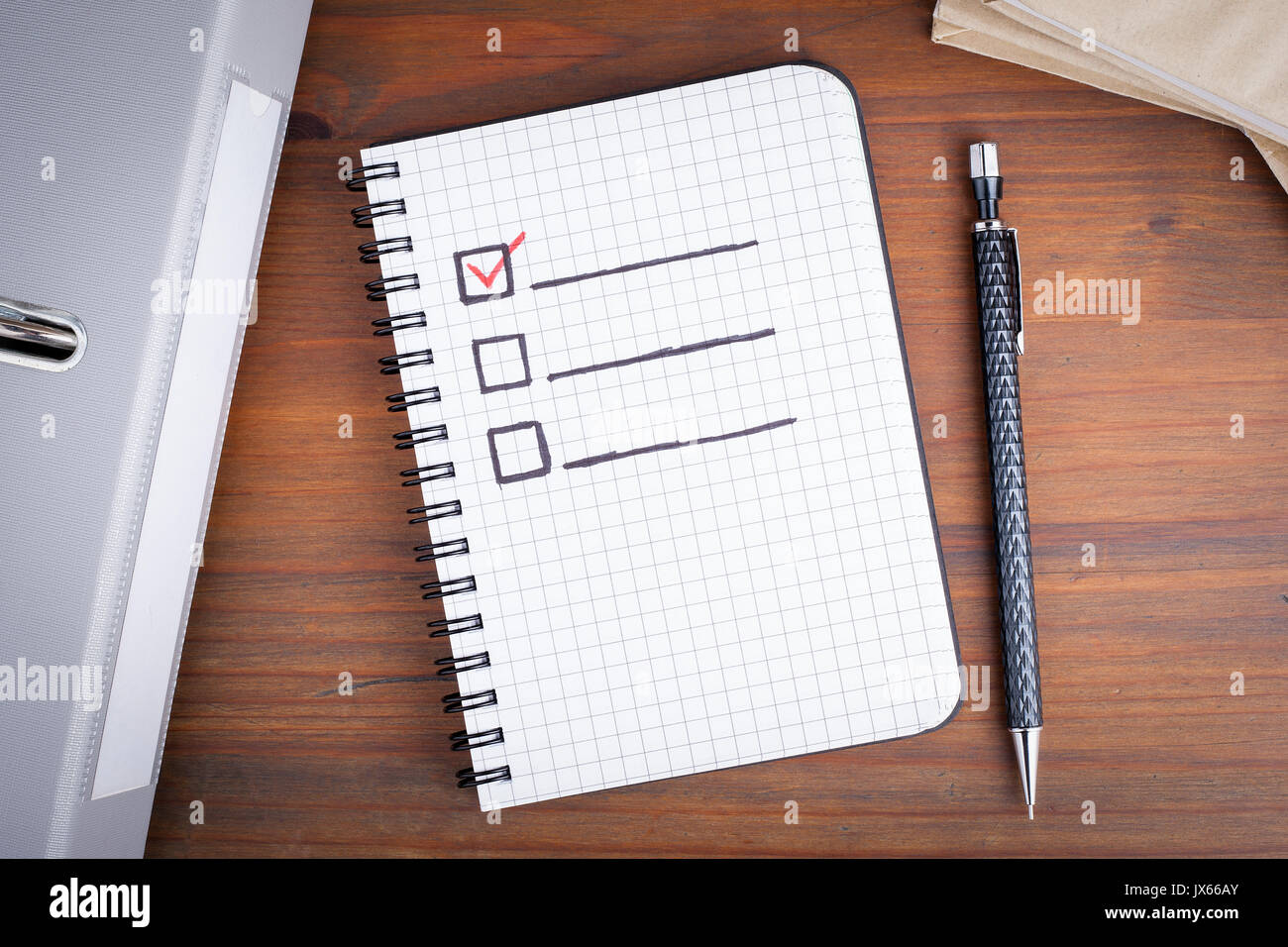 Book with blank checklist on wooden table. Stock Photo