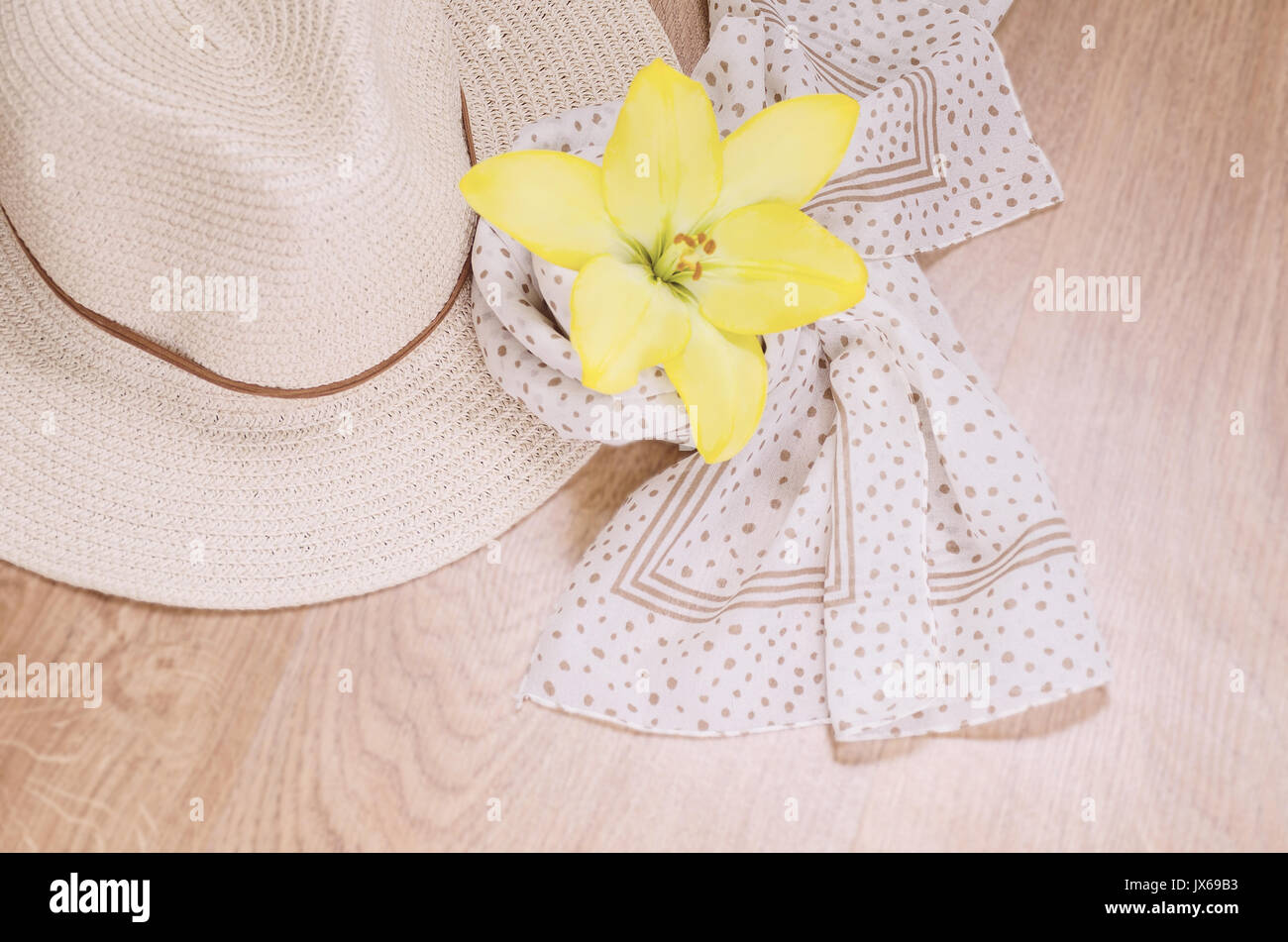 Straw hat, a light scarf and a jellied flower on a wooden background. Things for a trip or a trip out of town for a weekend. Romantic mood. Flat lay.  Stock Photo
