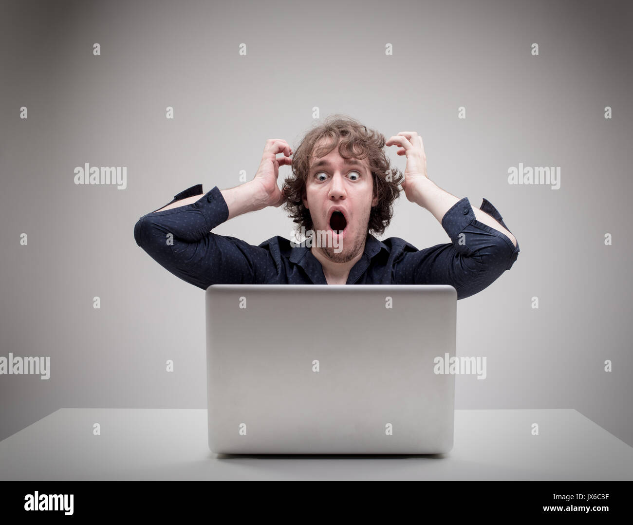 businessman very shocked about something he just viewed or read on the internet or viruses or application problems Stock Photo
