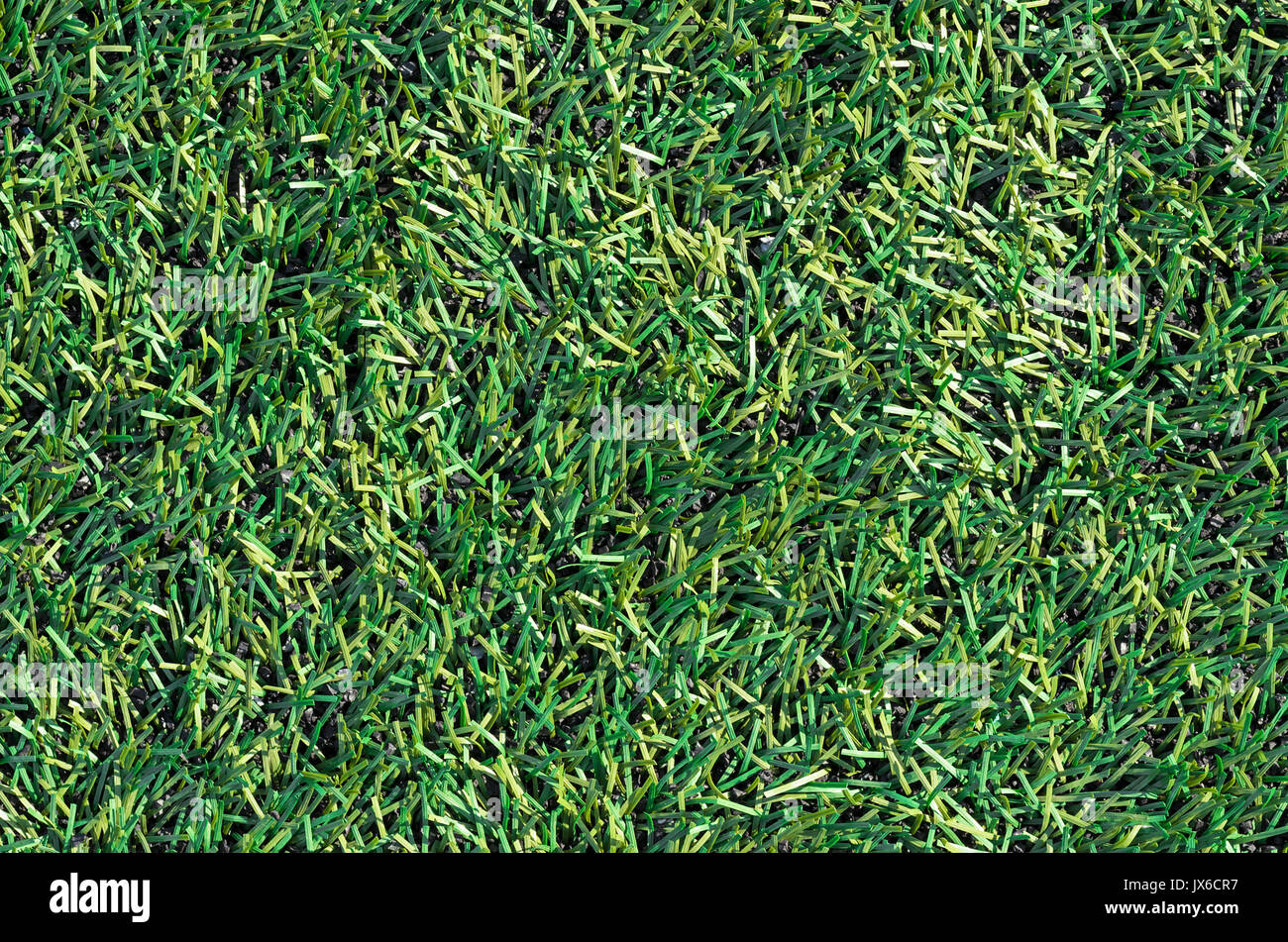 Fake Grass used on sports fields for soccer, baseball, golf and football. Closed-up of artificial green grass texture background. Green abstract lawn. Stock Photo