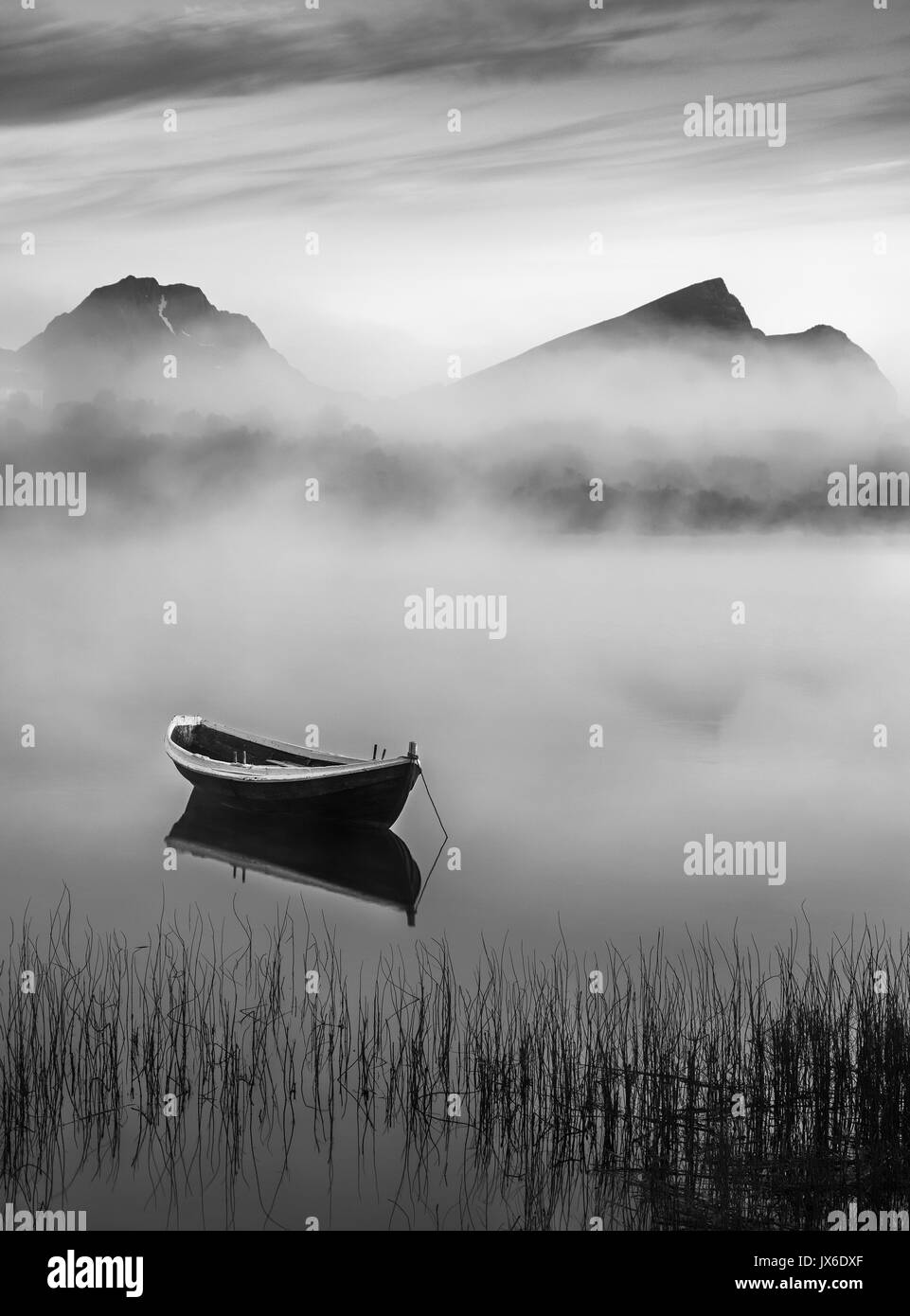 Very peaceful summer night with wooden boat and fog in Lofoten, Norway Stock Photo