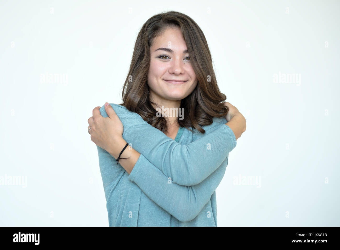 Happy caucasian woman hugging herself with natural emotional enjoying face. Stock Photo