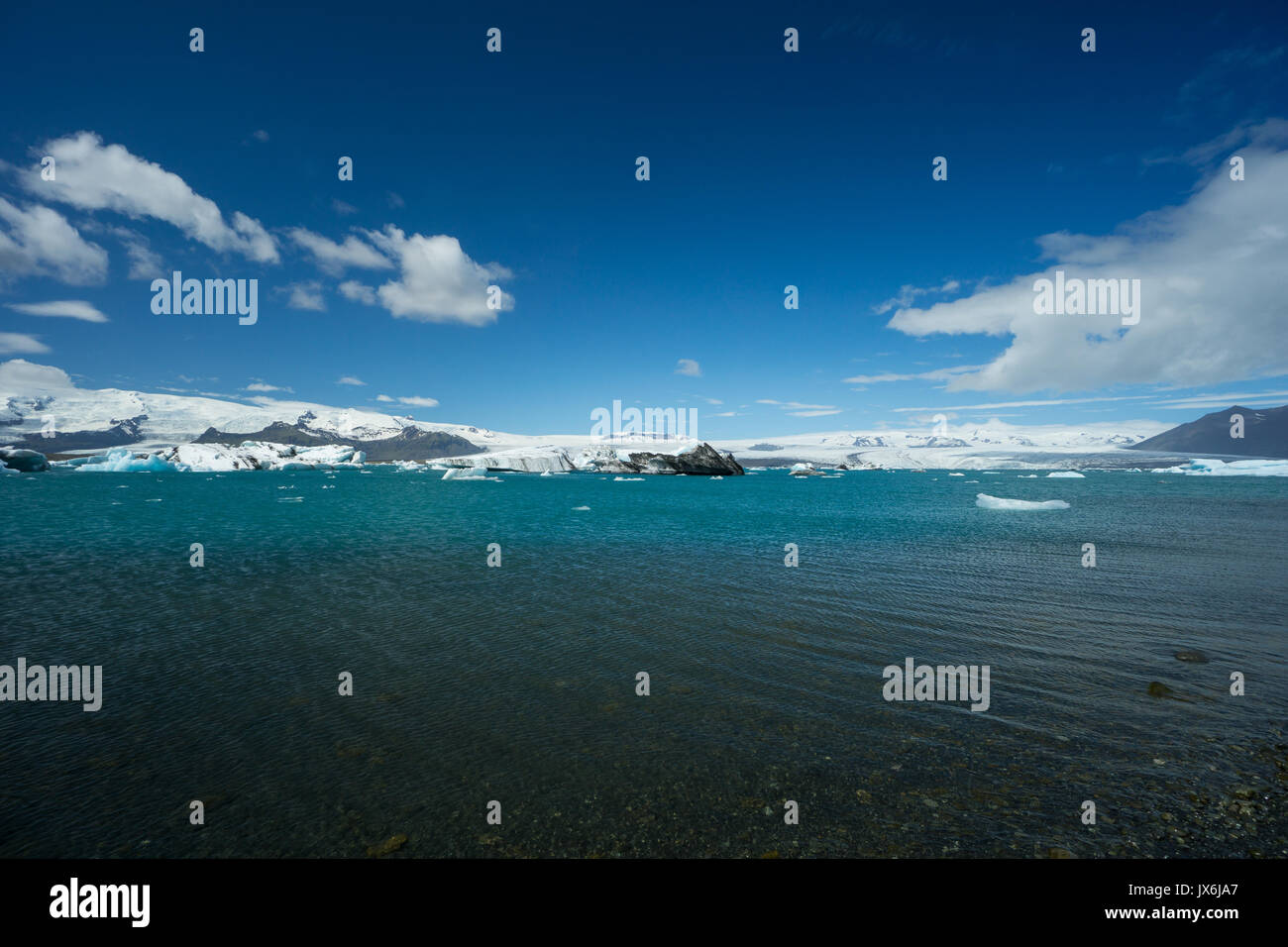 Iceland - Blue sky over agitated turquoise clear water of glacial lake Stock Photo