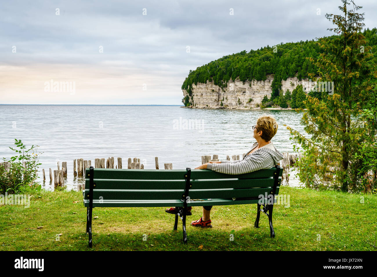 Woman is relaxing on a bench in Fayette State Park in Upper Peninsula, Michigan Stock Photo