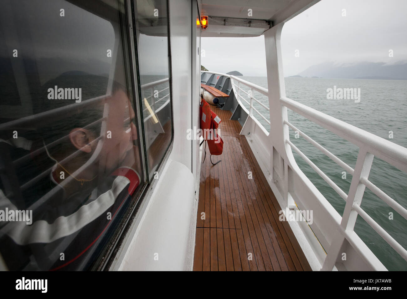 A passenger looks through a window at the surrounding landscape on a rainy day. Stock Photo