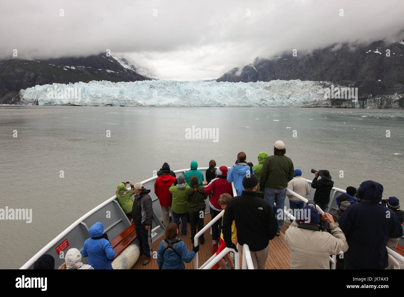 During an expedition on a cruise ship, passengers observe and photograph a nearby glacier. Stock Photo