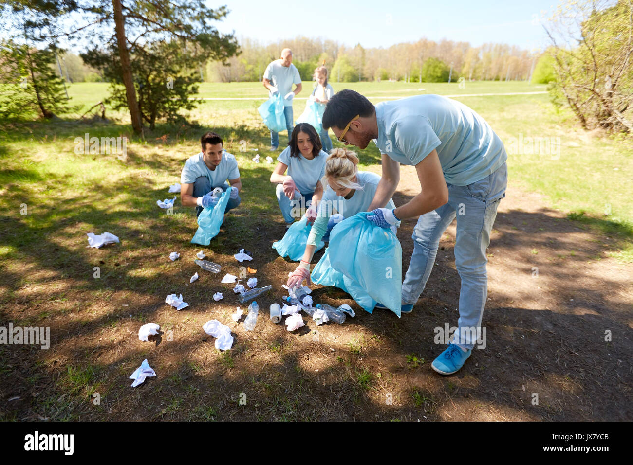 volunteers with garbage bags cleaning park area Stock Photo