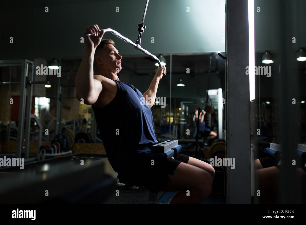 man flexing muscles on cable machine in gym Stock Photo Alamy