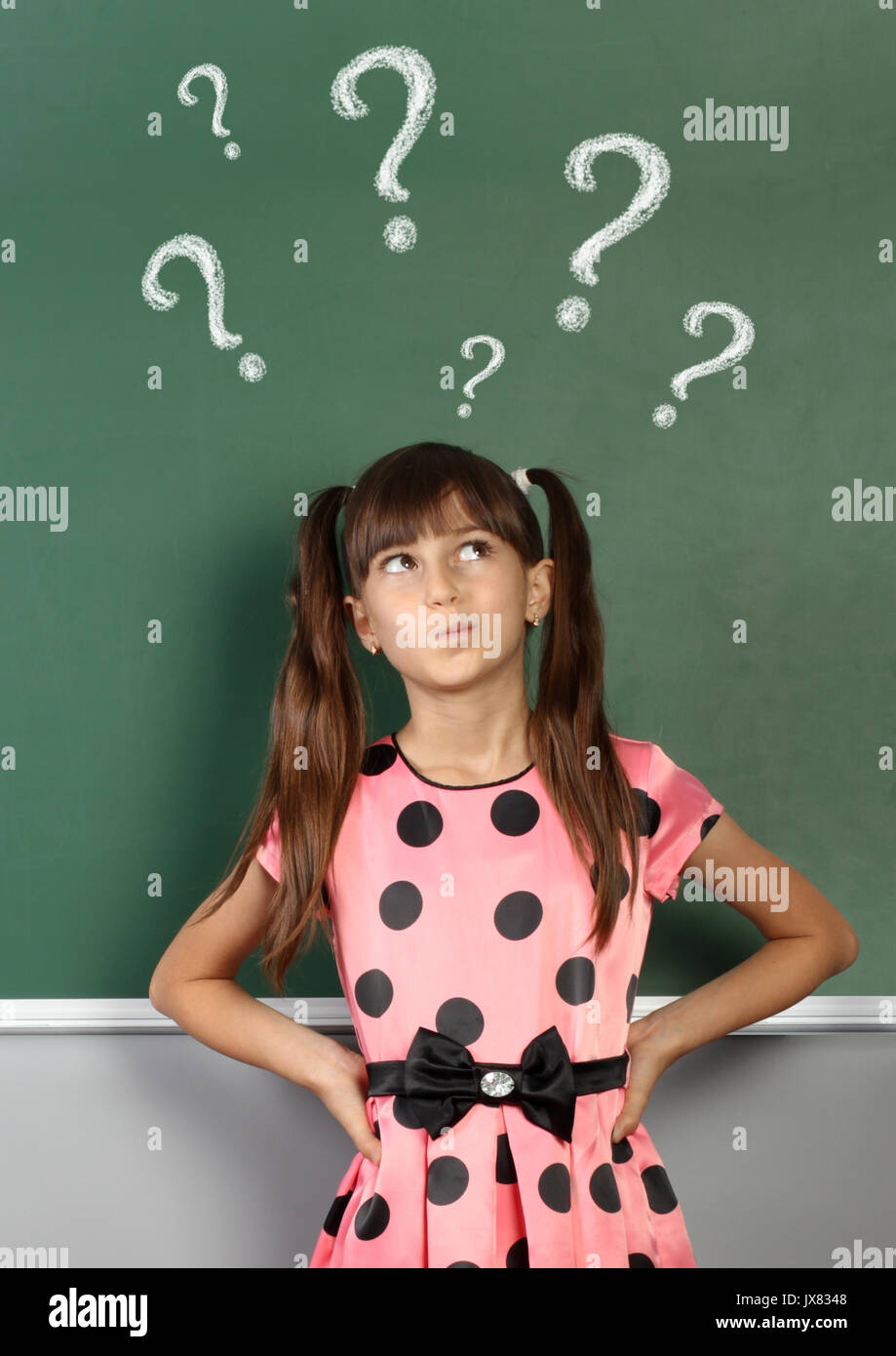 Child with question mark on school blackboard Stock Photo