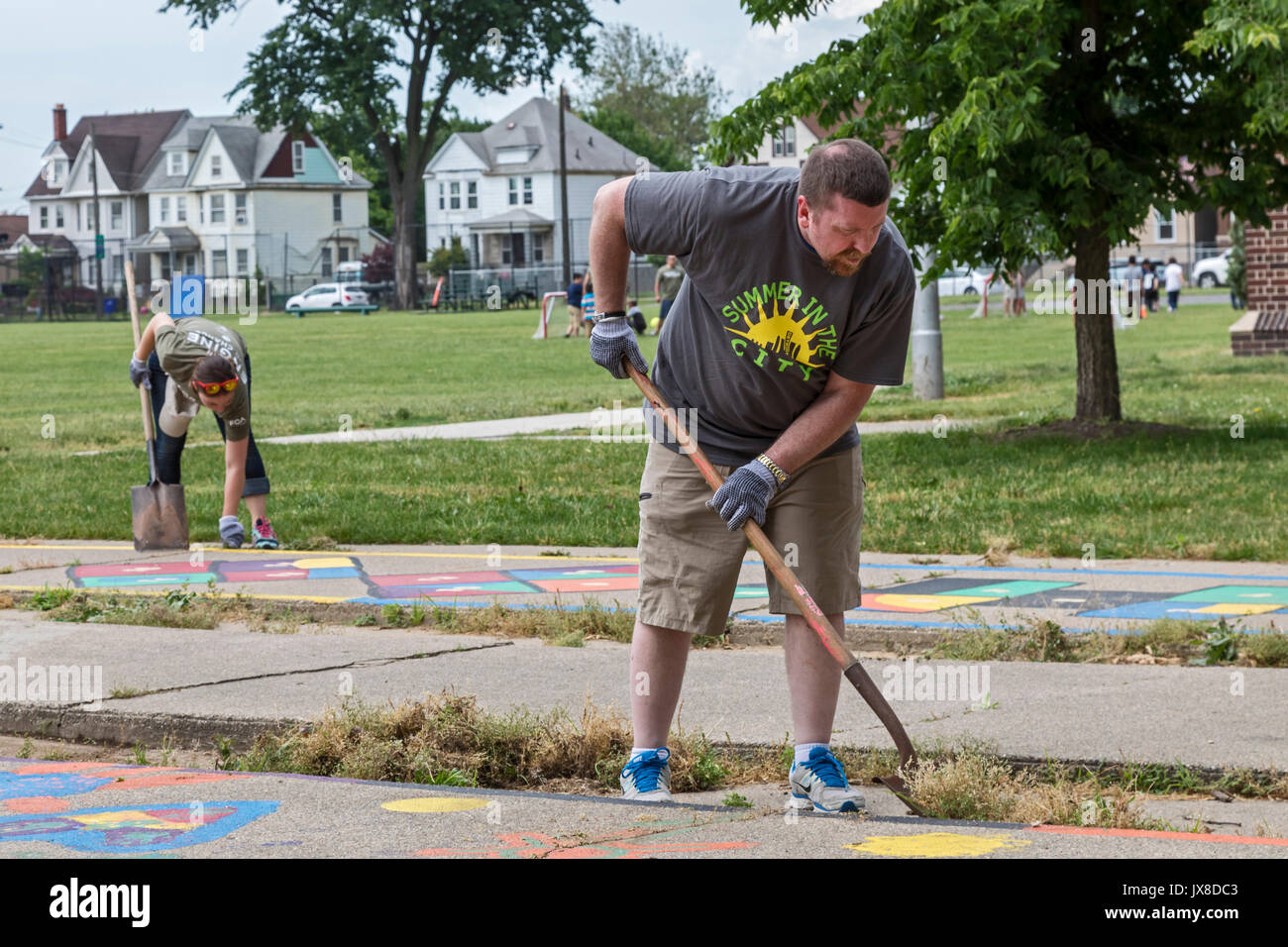 Detroit, Michigan - Volunteers from Fiat Chrysler Automobiles (FCA) clean weeds from the playground at Clark Park as part of the Summer in the City pr Stock Photo