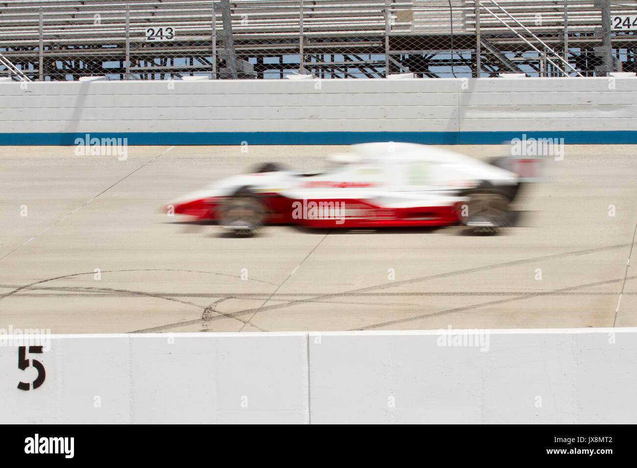 IRL race car blurred on track of motor speedway. Stock Photo