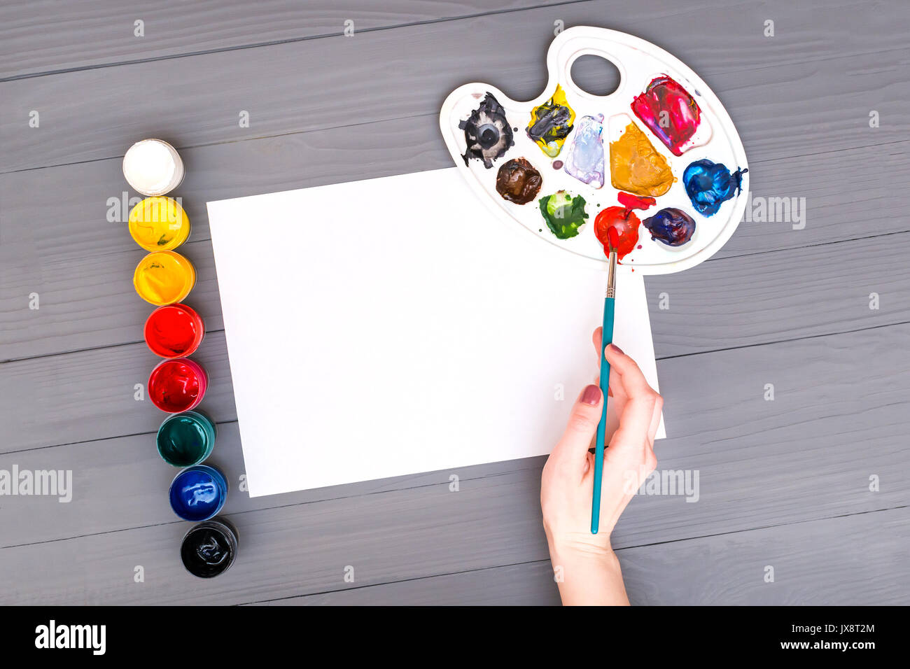 Hand holds brush over sheet Stock Photo Alamy