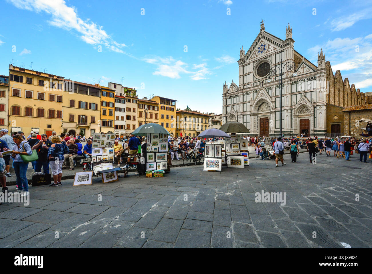 Tourists shop the local artists and artwork in Piazza di Santa Croce on a busy day in front of the Basilica di Santa Croce Stock Photo