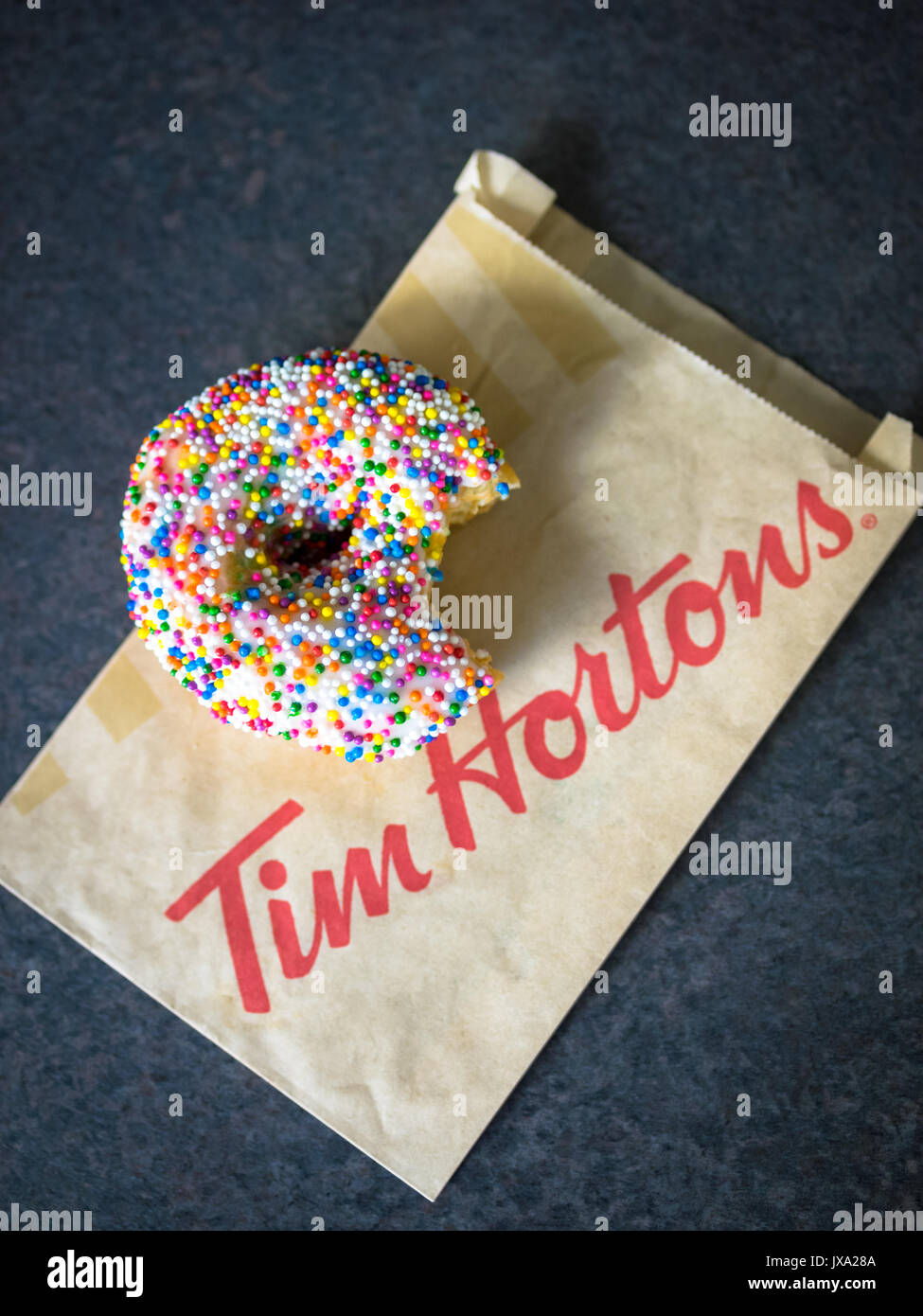 A vanilla dip donut (sprinkle donut, rainbow sprinkle donut) from Tim
