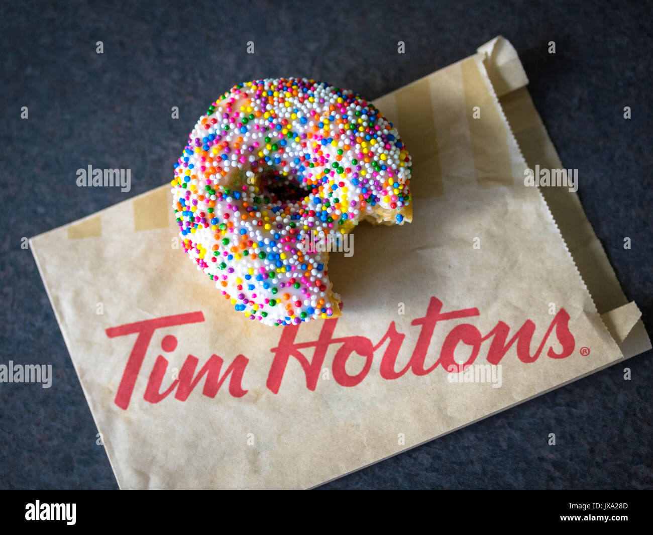 A vanilla dip donut (sprinkle donut, rainbow sprinkle donut) from Tim