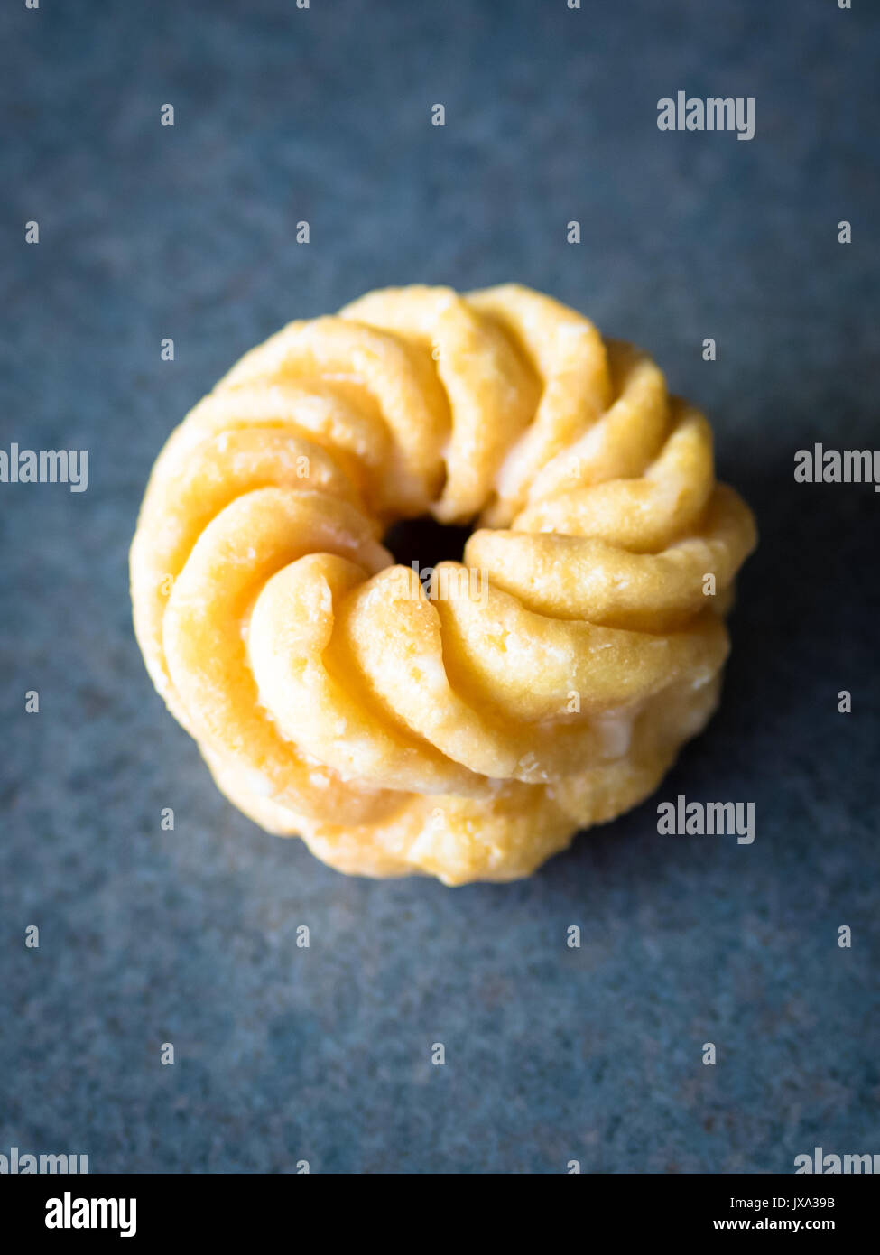 A honey cruller donut from Tim Hortons, a popular Canadian fast food restaurant and donut shop. Stock Photo