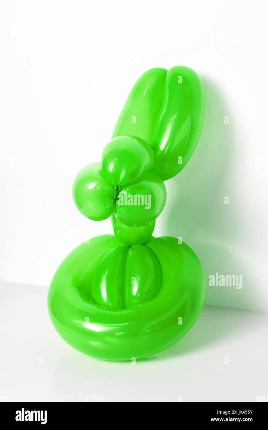 Simple green twisted balloon animal rabbit on white. Toy of balloons