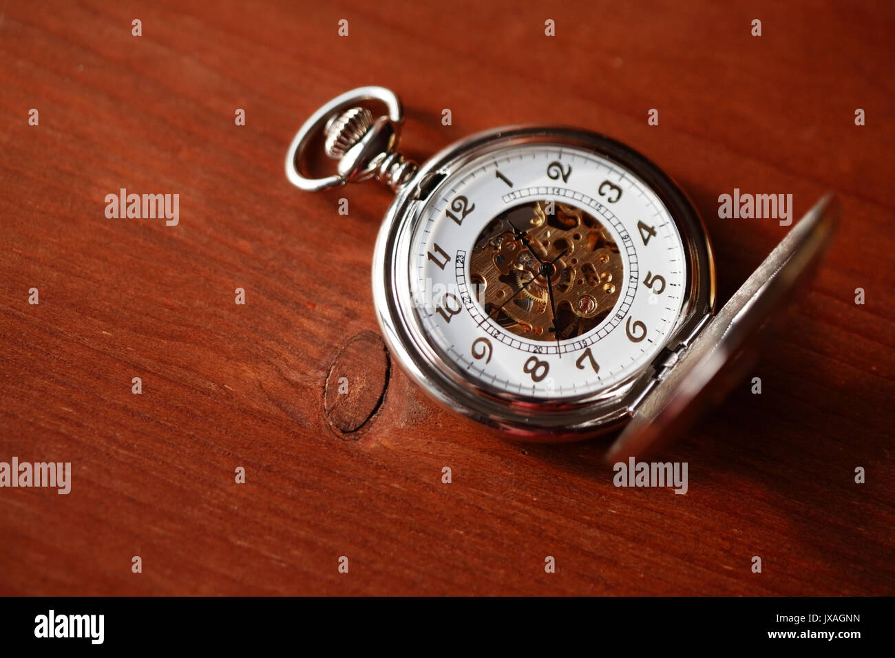 Pocket watch with open lid on wooden surface with copy space Stock